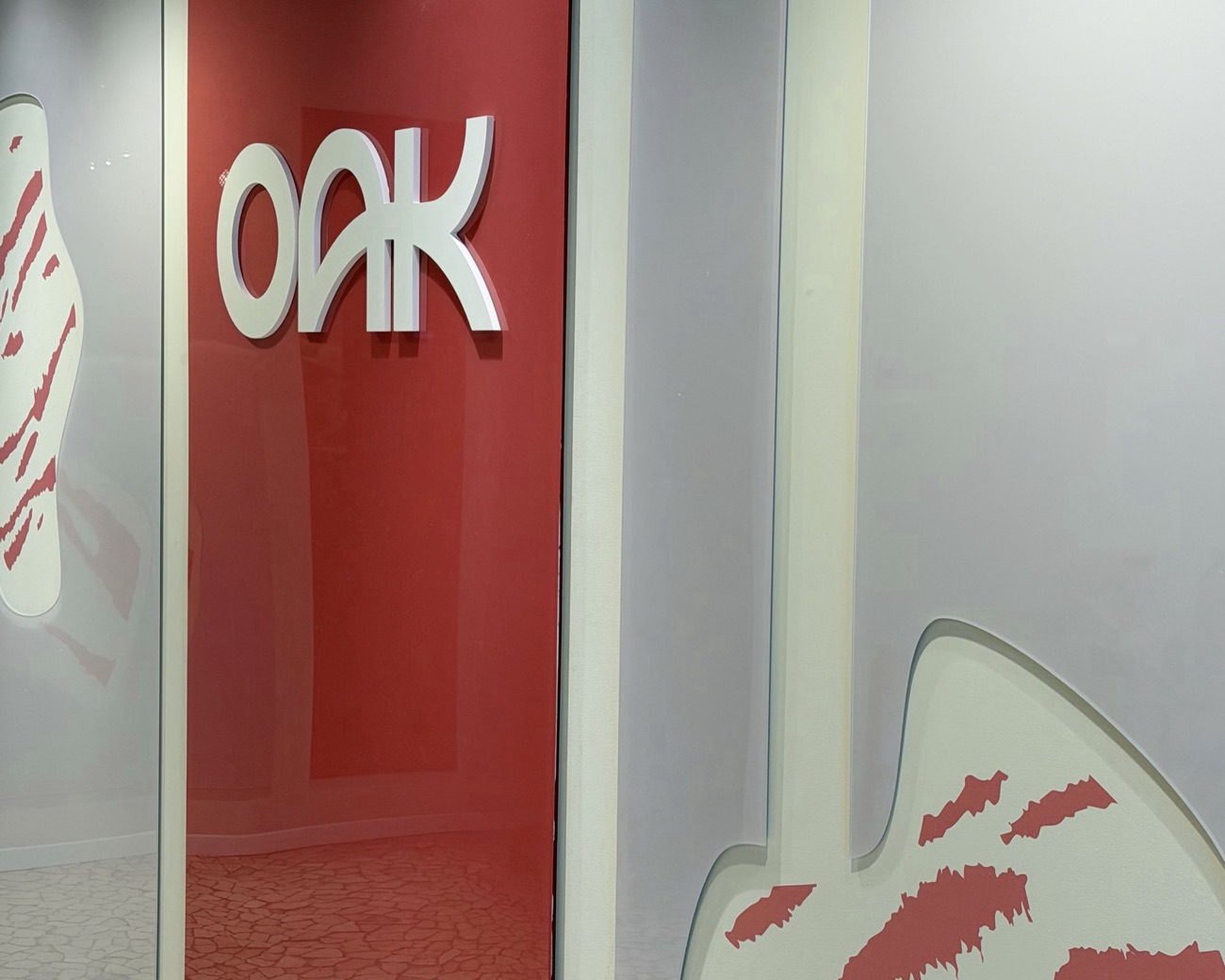 כניסה לחדר שיחה בקיר אדום, לוגו oak ומחיצות זכוכית מודפסות